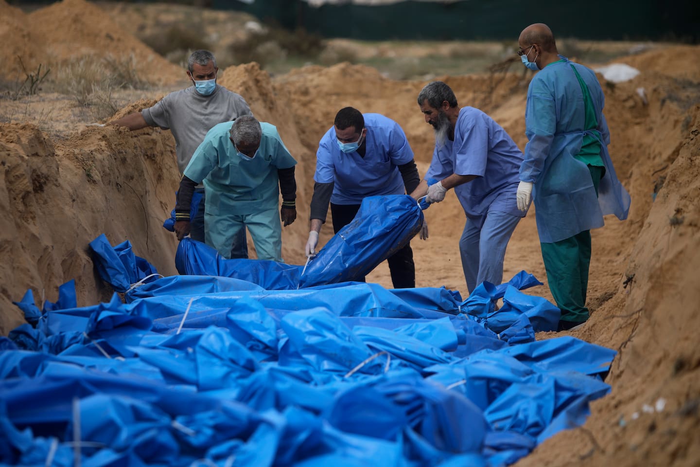 Over 70 prosent av de over 18.000 som er drept på Gazastripen de siste to månedene, var ifølge helsemyndighetene barn og kvinner. Her legges ofre i en massegrav i Khan Younis. Foto: AP / NTB