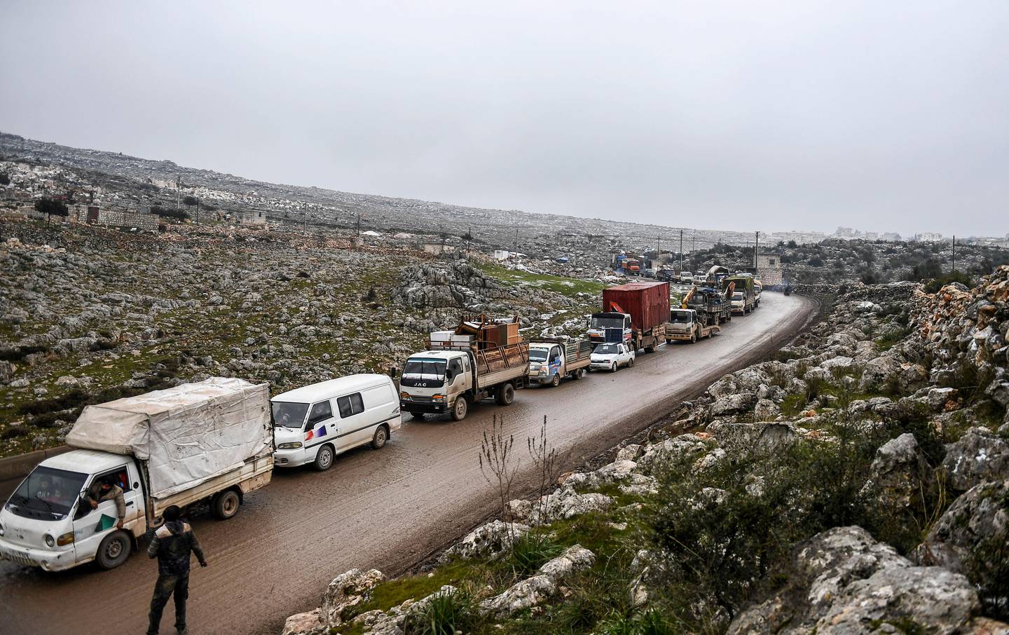 Syrian civilians flee from Idlib in rain toward the north to find safety inside Syria near the border with Turkey, Thursday, Feb. 13, 2020. Syrian troops are waging an offensive in the last rebel stronghold according to news reports by a Turkish news agency.( AP Photo)