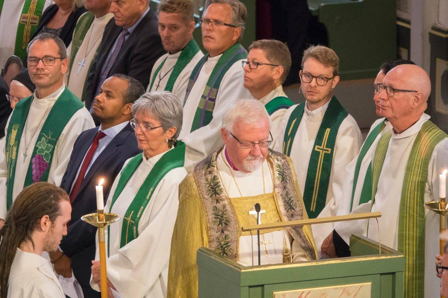 Med proster og kirkesjefer i ryggen leder Kvarme bibelteksten på avskjedsgudstjenesten i Oslo domkirke.