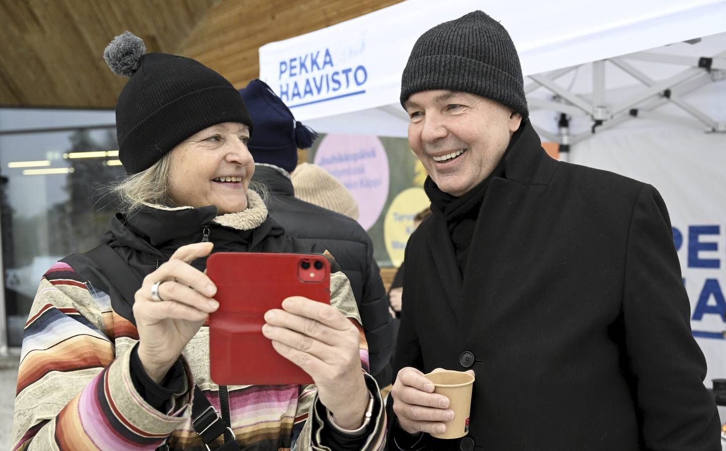 De Grönas presidentkandidat Pekka Haavisto tar et bilde sammen med en støttespiller under et valgkamparrangement i Helsingfors i desember. Foto: Vesa Moilanen / Lehtikuva via AP / NTB