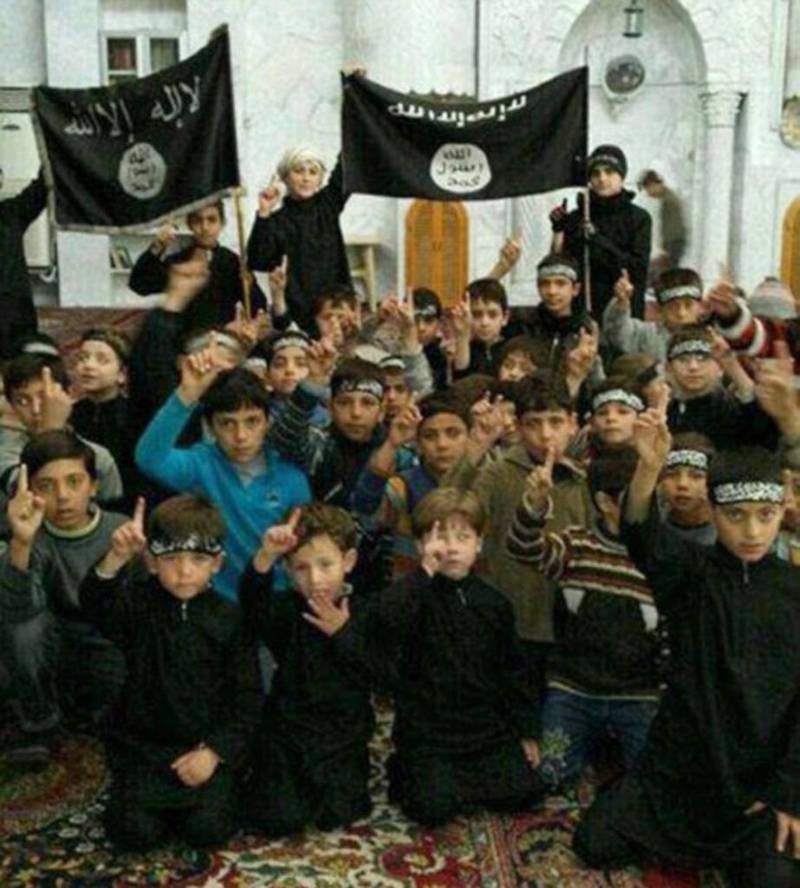 Bildet av barn som poserer med IS-flagg i den syriske byen Raqqa, er et av bildene som gruppen Raqqa Is Being Slaughtered Silently har spredt til internasjonal presse.