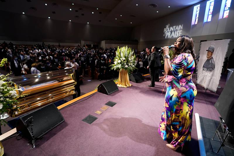 A singer performs by the casket of George Floyd during a funeral service for Floyd at The Fountain of Praise church Tuesday, June 9, 2020, in Houston. (AP Photo/David J. Phillip, Pool)