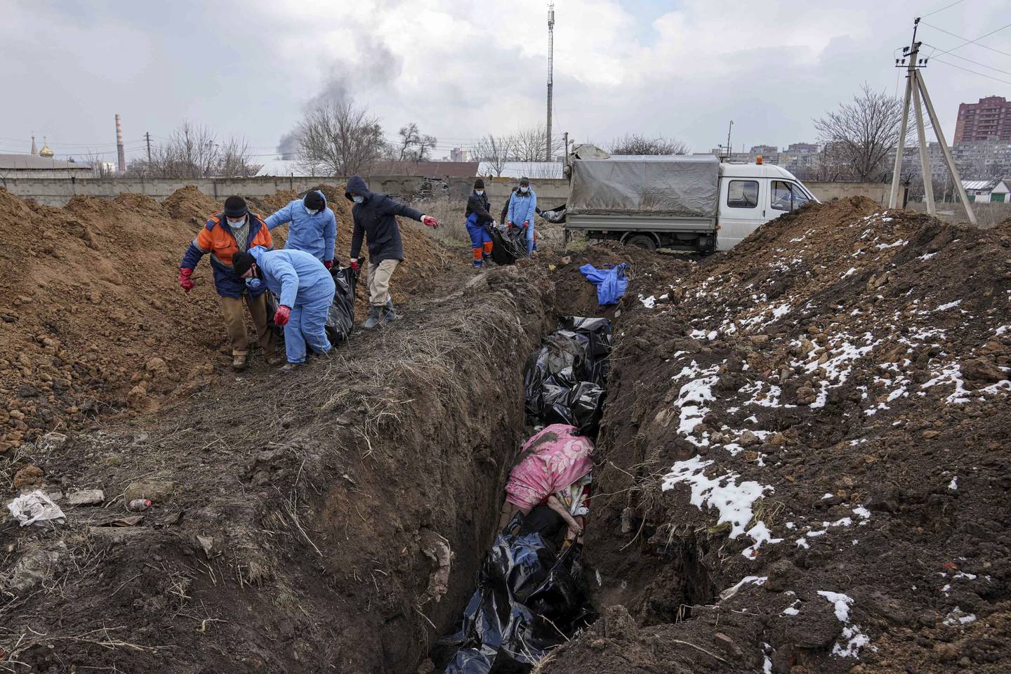 Lik blir lagt i massegraver i utkanten Mariupol i starten av mars. Foto: Jevgenij Maloletka / AP / NTB