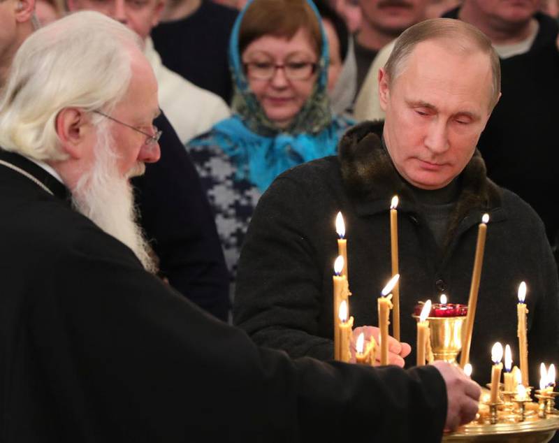 Russlands president Vladimir Putin tenner lys under ortodoks julemesse i St. Georg-klosteret i Novgorod 6. januar.