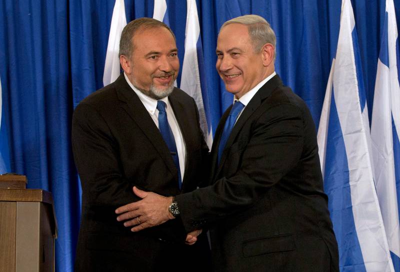 FILE - In this Oct. 25, 2012, file photo, Israeli Prime Minister Benjamin Netanyahu, right, and former Israeli Defense Minister Avigdor Lieberman shake hands in front of the media after giving a statement in Jerusalem. Israel's parliament voted to dissolve itself early Thursday, May 30, 2019, sending the country to an unprecedented second snap election this year as Netanyahu failed to form a governing coalition before a midnight deadline. (AP Photo/Bernat Armangue, File)