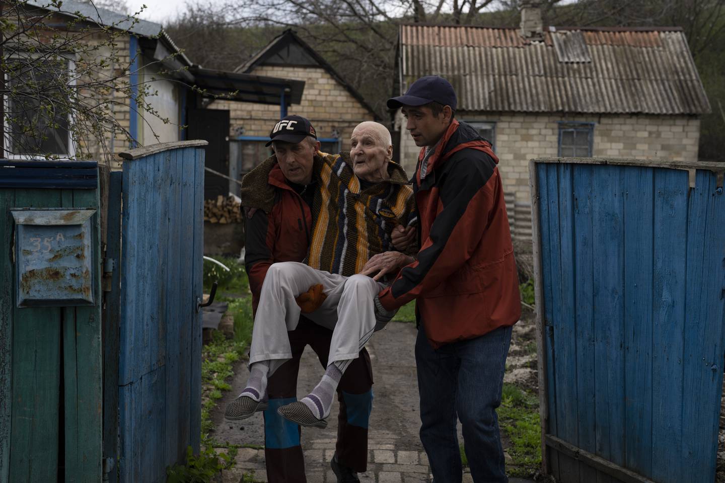 Elderly people are evacuated from a hospice in Chasiv Yar city, Donetsk district, Ukraine, Monday, April 18, 2022. At least 35 men and women, some in wheelchairs and most of them with mobility issues, were helped by volunteers to flee from the region that has been under attack in the last weeks. They are being transported to Khmelnytskyi, in western Ukraine. (AP Photo/Petros Giannakouris)