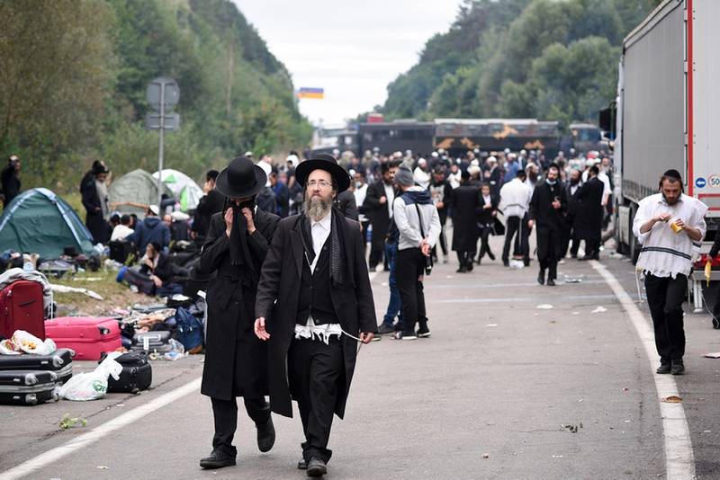 Jewish pilgrims gather on the Belarus-Ukraine border, in Belarus, Tuesday, Sept. 15, 2020. About 700 Jewish pilgrims are stuck on Belarus' border due to coroavirus restrictions that bar them from entering Ukraine. Thousands of pilgrims visit the city each September for Rosh Hashana, the Jewish new year. However, Ukraine closed its borders in late August amid a surge in COVID-19 infections. (TUT.by via AP)