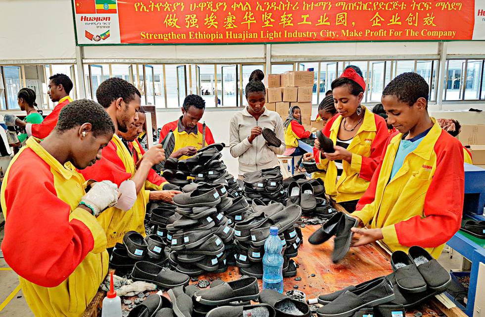 FILE - In this Thursday, Jan. 5, 2017, file photo, Ethiopian factory workers sort through shoes at the Chinese company Huajian's plant in the Lebu Industrial complex near Addis Ababa, Ethiopia. The company that manufactured Ivanka Trump shoes and has been accused of serious labor abuses is being celebrated in a blockbuster propaganda film for extending China's influence around the globe. (AP Photo/Elias Meseret, File)