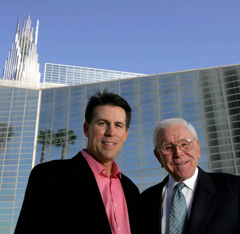 **FILE** Robert A. Schuller, left, poses for a photo with his father, Robert H. Schuller, outside the Crystal Cathedral  Feb. 9, 2006, in Orange, Calif. Just three years after the changeover of leadership for the Crystal Cathedral, a bitter family feud has left the younger Schuller in exile, a rotating roster of visiting preachers fills the "Hour of Power," and the church itself is mired in debt, with donations dropping. (AP Photo/Chris Carlson, File)