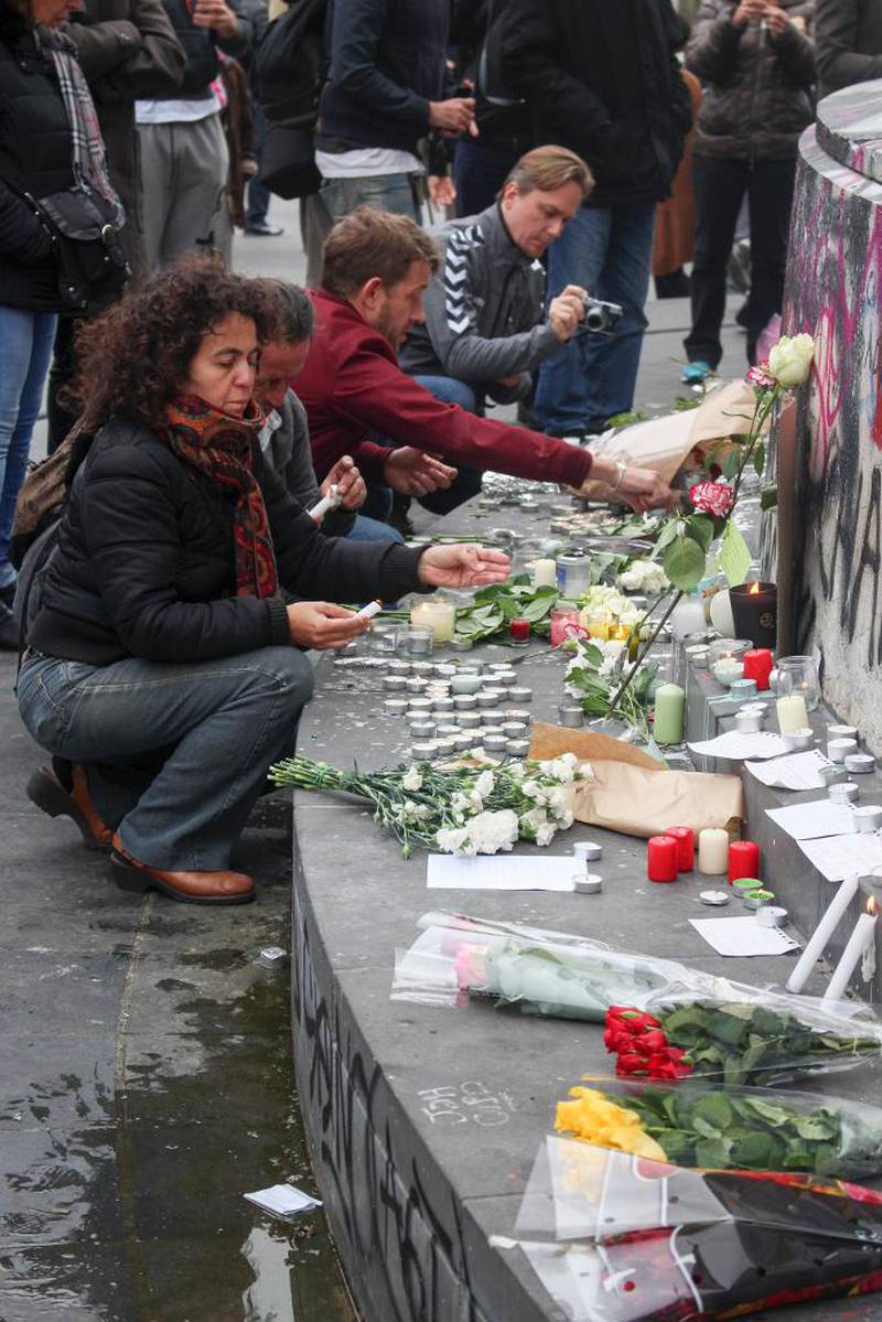 Folk tenner lys og legger ned blomster for dem som omkom fredag.