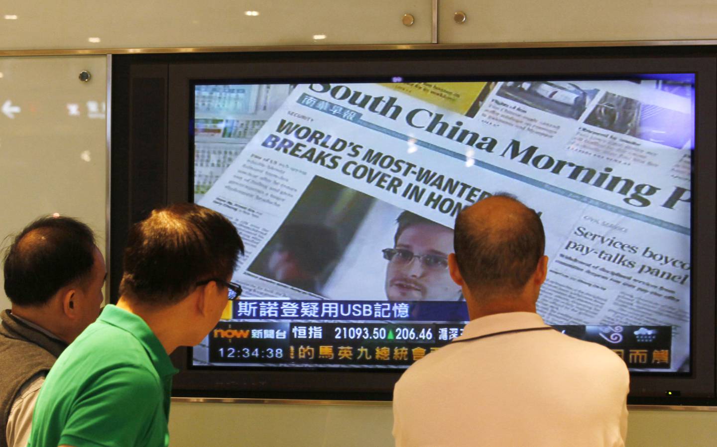 A TV screen shows the news report of Edward Snowden, former CIA employee who leaked top-secret documents about sweeping U.S. surveillance programs, at a shopping mall in Hong Kong Friday, June 14, 2013. A popular Communist Party-backed newspaper urged China's leadership to milk a former U.S. contractor for more information rather than send him home, saying his revelations about secret American surveillance programs concern China's national interest.(AP Photo/Kin Cheung)