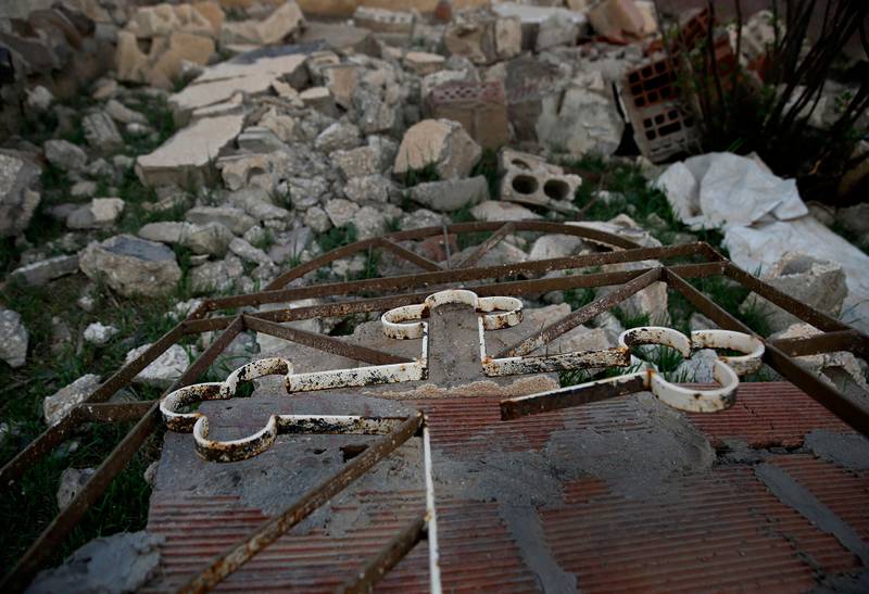 In this Sunday, April 1, 2018 photo, a cross lies in the rubble of a destroyed church that was blown up by Islamic State militants in 2015, in the deserted village of Tal Jazeera, northern Syria. Tal Jazeera is one of more than 30 villages along the Khabur River that were destroyed when Islamic State group militants rampaged through, kidnapping 226 residents and sending the rest fleeing. From nearly 20,000 Assyrians in Syria before the war in 2011, there are around 1,000, according to local activists. (AP Photo/Hussein Malla)