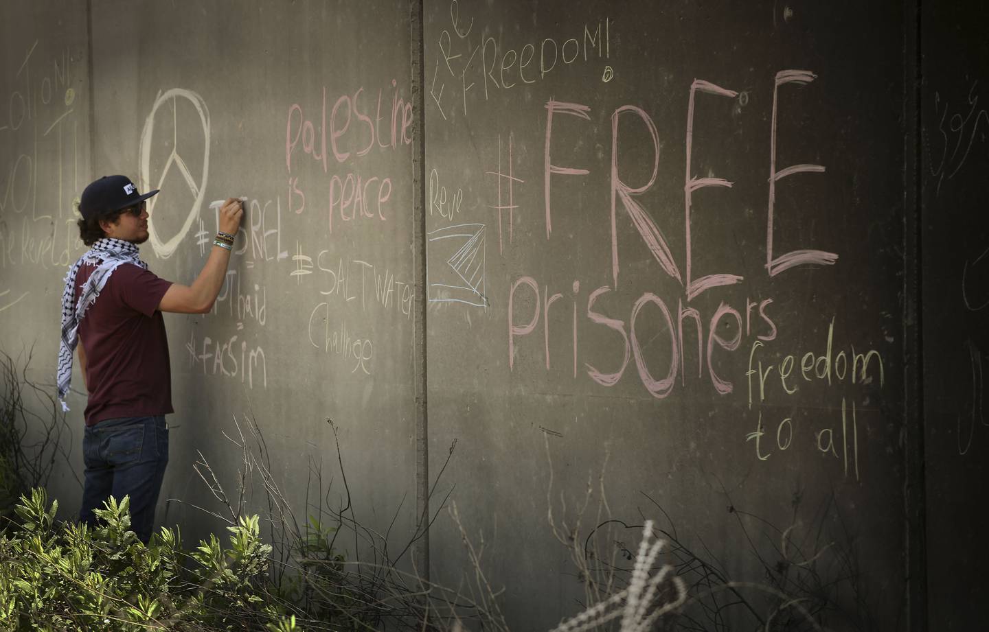 Israel har lenge høster krass internasjonal kritikk for fengsling av barn ned i tolvårsalderen. Denne demonstranten malte i 2017 slagord på den ulovlige muren Israel har bygd på Vestbredden med krav om løslatelse av palestinske fanger. Foto: Nils-Inge Kruhaug / NTB