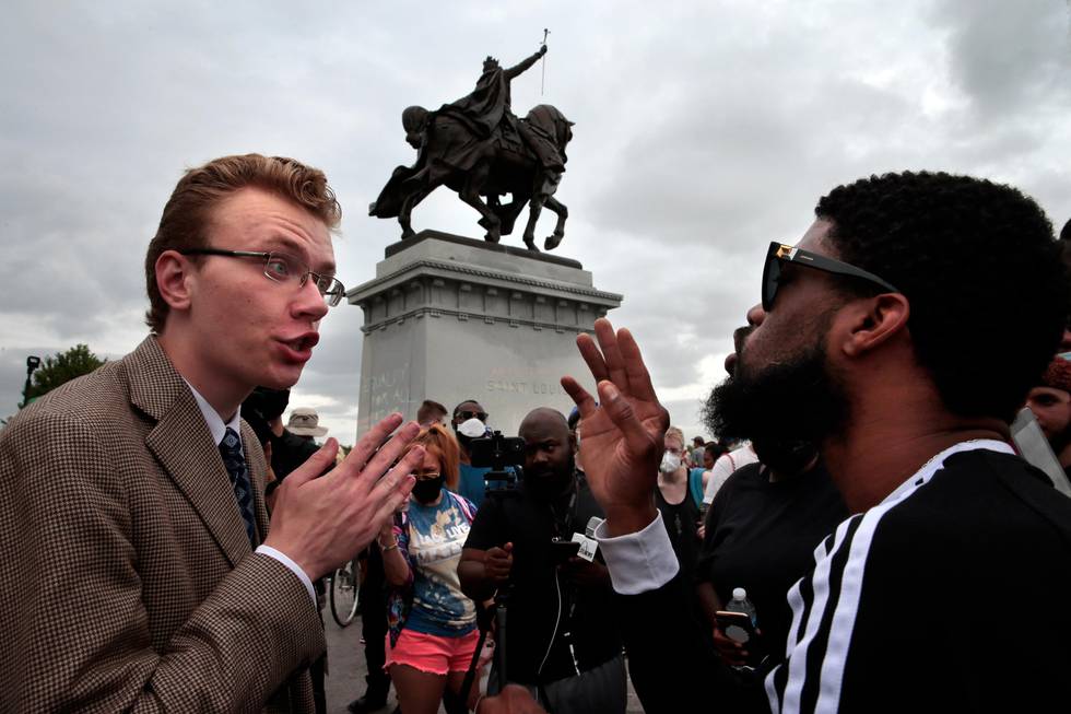 Mark Williams, left, of Sullivan, Mo., debates the worthiness of a statue of King Louis IX in Forest Park with a man who gave his name as Horus during a rally that brought various opinions to the top of Art Hill on Saturday, June 27, 2020, St. Louis. "This is hate against the Catholic church," said Williams, calling for a conversion of St. Louis residents. "If 99 percent of people are Catholic, our racial problems go away."  (Robert Cohen/St. Louis Post-Dispatch via AP)