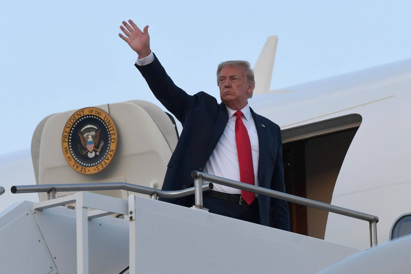 President Donald Trump waves from the top of the steps of Air Force One at Morristown Municipal Airport in Morristown, N.J., Sunday, Aug. 9, 2020. Trump is returning to Washington after spending the weekend at the Trump National Golf Club. (AP Photo/Susan Walsh)