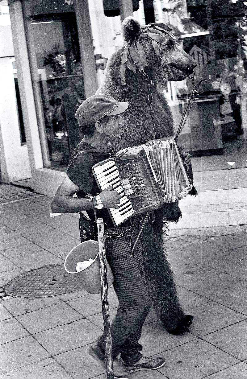 Blagoevgrad, Bulgaria - August 10, 1999: A man with dancing bear accordion and on city streets.