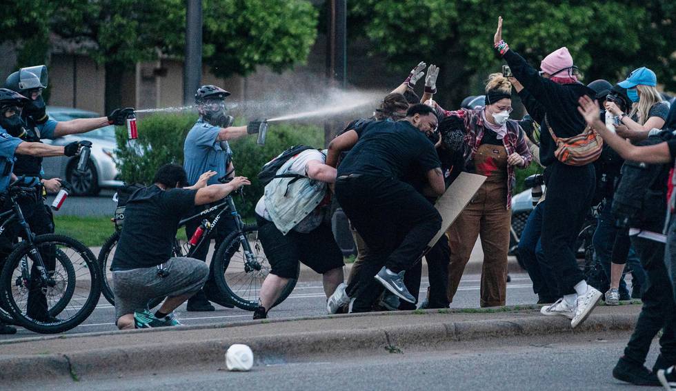 Police officers use pepper spray as they try to disperse people during a protest in Minneapolis on Sunday, May 31, 2020. Protests were held in U.S. cities over the death of George Floyd, a black man who died after being restrained by Minneapolis police officers on May 25. (Elizabeth Flores/Star Tribune via AP)