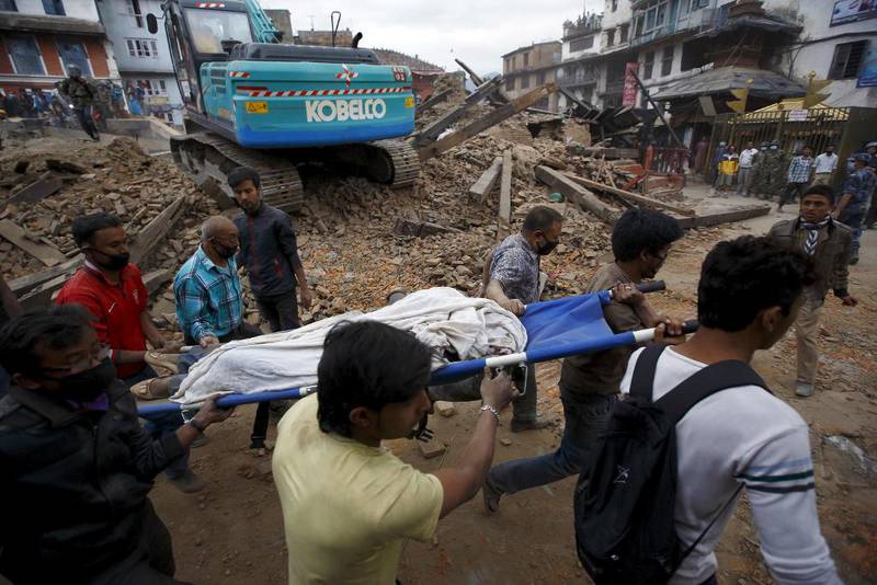 Redningsarbeidere bærer en båre med et av menneskene som mistet livet i jordskjelvet i Katmandu lørdag.