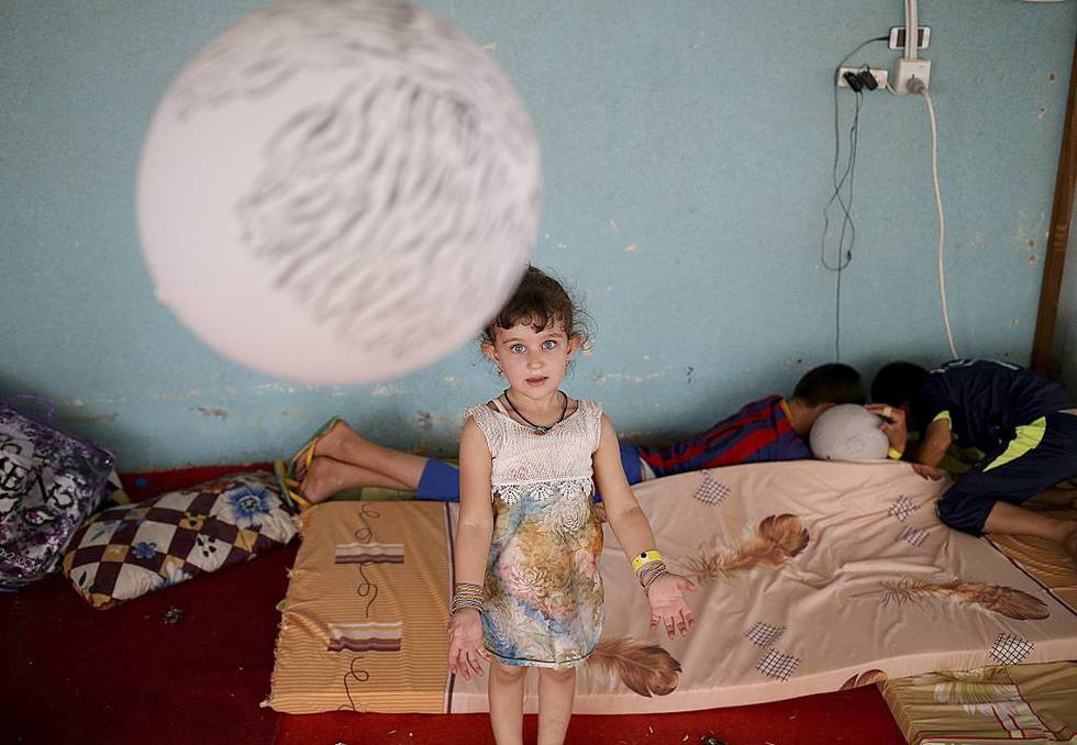 En jente leker med en ballong i et mideltidig losji for fordrevne kristne familier nær Arbil i Irak. Millioner av kristne, muslimer, hinduer og andre religiøse måtte i fjor flykte på grunn av sin tro, konkluderer en ny ameriansk rapport.